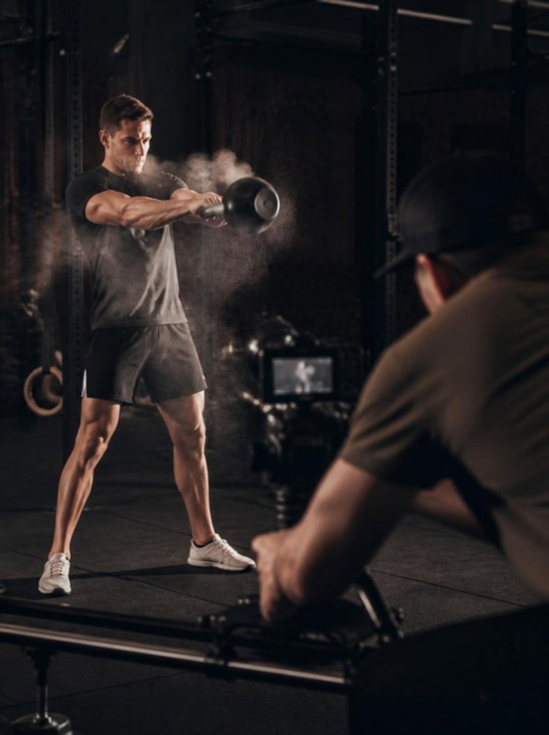 Videographer filming a fitness coach swinging a kettlebell for a coach profile video
